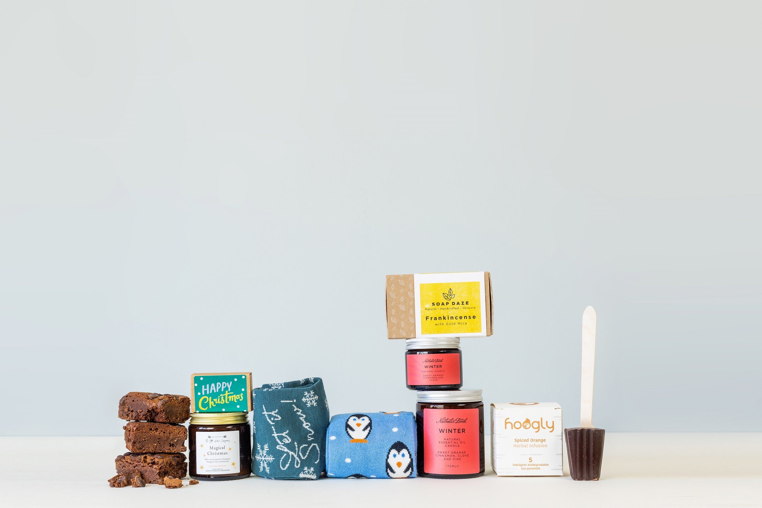 Sustainable Corporate Christmas Gifts - Image of a selection of products available for festive corporate gifts including Chocolate Brownies, Magical Christmas Candle, Festive Bamboo Socks, Winter Candles, Frankincense Soap, Spiced Orange Tea Bags and Hot