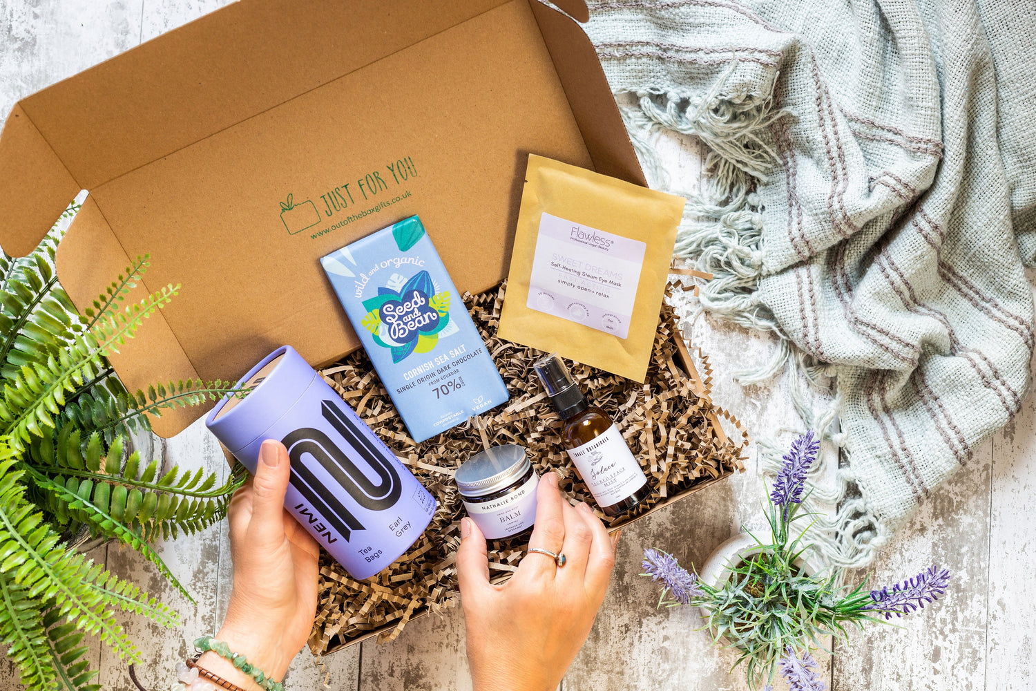 Gift box full of sustainable treats including chocolate, tea, self-care gifts