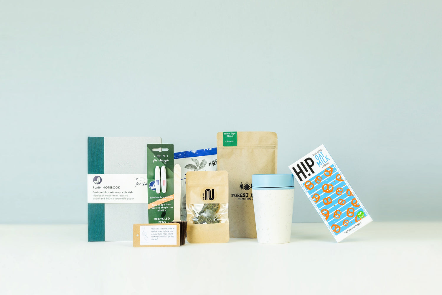 Gender Neutral Onboarding Gifts - image of contents of gift box including notebook, ground coffee, crisps, tea bags, pens, chocolate and keep cup